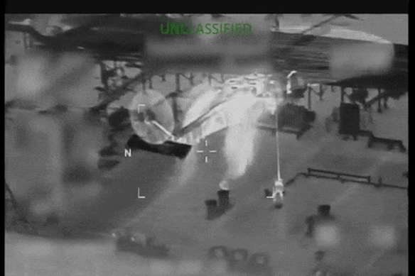 A US Coast Guard helicopter hovers above the tanker as personnel descend to its deck.