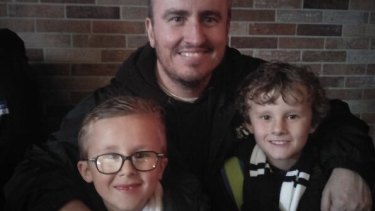 Collingwood fan Daniel Slattery with his sons Callum, 11, and Mitchell, eight.