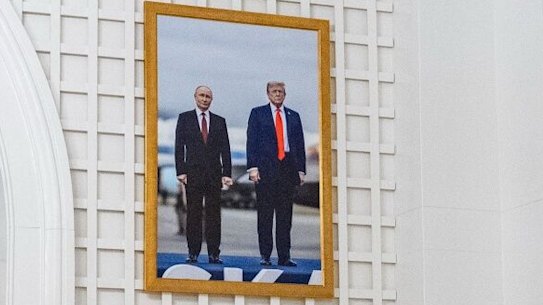 Photographs showing US President Donald Trump with Russian President Vladimir Putin and President Trump and one of his grandchildren hang in the Palm Room of the White House in Washington, DC, US, on Tuesday, Jan. 27, 2026. Trump threw his support behind a legislative proposal that would expand sales of higher-ethanol E15 gasoline as he looked to build support for his economic record with a crowd that included farmers in Iowa. Photographer: Kent Nishimura/Bloomberg