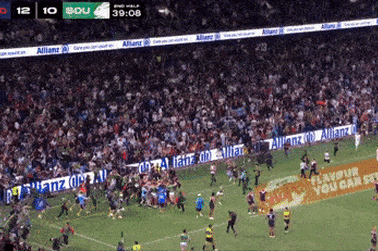 Fans rush the field as Alex Johnston breaks the NRL try-scoring record.