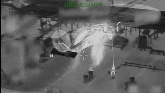 A US Coast Guard helicopter hovers above the tanker as personnel descend to its deck.
