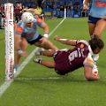 Jasmine Peters dives over two Blues defenders to score a try in the corner for the Queensland Maroons.