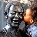  A young South African girl names Malika is lifted by her mother to kiss a statue of former South African President Nelson Mandela before a service conducted by Archbishop Desmond Tutu at the Nelson Mandela Foundation on December 9, 2013 in Johannesburg, South Africa. 