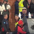 Gold Coast coach Damien Hardwick exchanges words with a fan as he makes his way through the Adelaide Oval crowd.