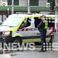 A mother has been repeatedly stabbed allegedly by a stranger armed with scissors, moments after the man is accused of punching her 10-year-old son in a random attack outside a police station in Melbourne’s CBD.
