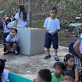 Dramatic footage of the 7.8 magnitude earthquake in the Philippines shows children screaming and running for cover as a small structure collapses during a school ceremony.