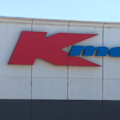 Kmart has been hauled to court over a home-brand nail glue linked to third-degree chemical burns and untested battery buttons in children’s watches.