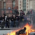 Tensions flared outside a barricaded high school, where masked and hooded protesters threw projectiles at police officers. The protests are part of a growing student movement demanding greater funding and resources for French schools.