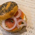 A bagel topped with salmon, red onion and cream cheese.