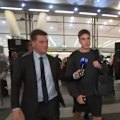 Sydney Swans player Jai Serong is swarmed by cameras after getting off a plane.