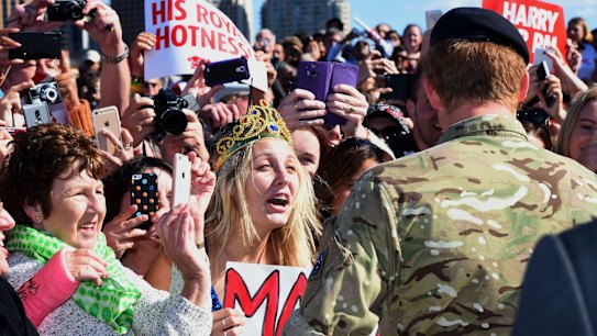 Britain's Prince Harry (R) meets members of the public during a visit to the Sydney Opera House in Sydney on May 7, 2015. The prince, known as Captain Wales, has been on a month-long embed with the Australian army before leaving the British forces, missing the birth of his niece Princess Charlotte earlier this month. AFP PHOTO / POOL / Dean Lewins
