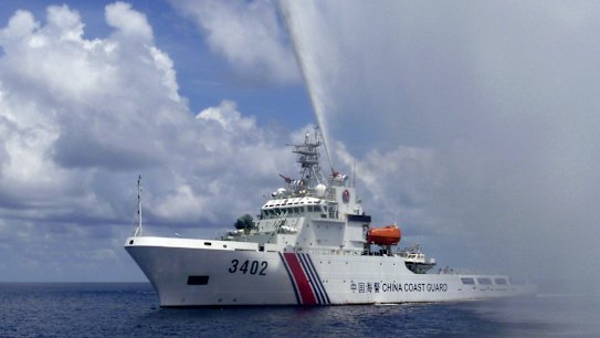 A Chinese Coast Guard boat sprays a water cannon at Filipino fishermen near Scarborough Shoal in the South China Sea last year.