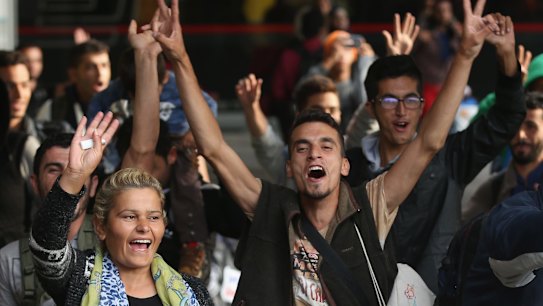 Migrants arriving with approximately 800 others on a train from Hungary react to the welcoming cheers of onlookers at Munich Hauptbahnhof main railway station in Munich, Germany. 