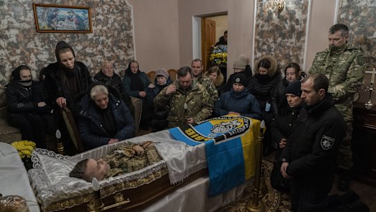 Relatives and friends mourn the body of senior police sergeant Roman Rushchyshyn in the village of Soposhyn, in the outskirts of Lviv, western Ukraine.