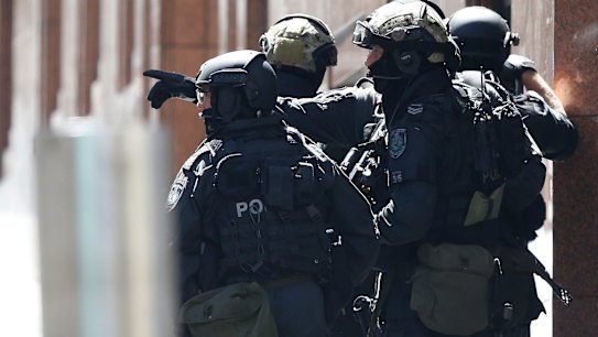 Hostages are being forced to hold an Islamic flag against the window of the Lindt Chocolat Cafe in Martin Place after reports a gunman had stormed the premises.