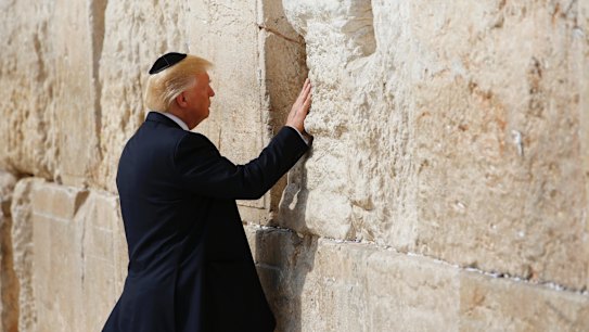 US President Donald Trump touches the Western Wall, Judaism's holiest prayer site, in Jerusalem's Old City on Monday.