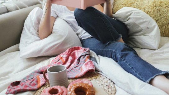 A comfy couch, doughnuts, coffee, and a book make this a pretty hyggelig nook. 
