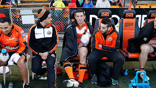 Braith Anasta of the Tigers sits on the bench with an ice pack on his left arm during the NRL match between the Wests Tigers and the Penrith Panthers in July 2014.
