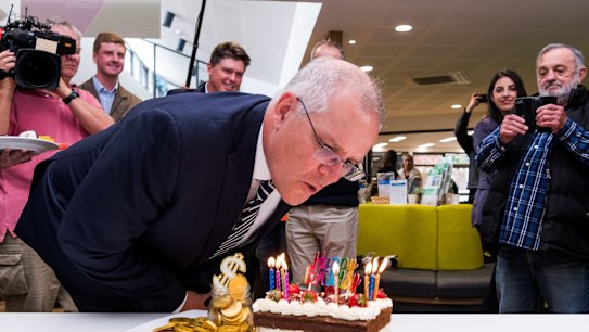  Prime Minister Scott Morrison visits Beveridge Community Centre in Beveridge, in the seat of McEwen. S 220413 ausvotes2022. With Richard Welch - Liberal Candidate for McEwen. Blowing out a birthday cake presented by the community. 