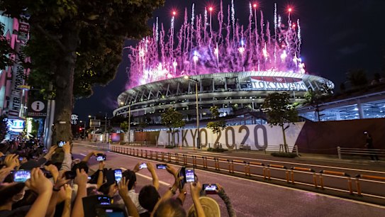 TOKYO, JAPAN - JULY 23: People take photographs of fireworks during the Opening Ceremony of the Tokyo 2020 Olympic Games at Olympic Stadium on July 23, 2021 in Tokyo, Japan. (Photo by Yuichi Yamazaki/Getty Images)