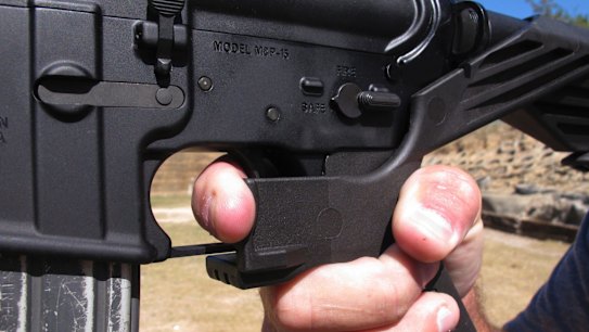 A US shooting instructor demonstrates the grip on an AR-15 rifle fitted with a bump stock.