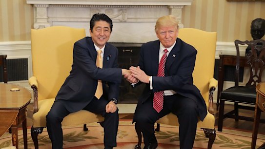 U.S. President Donald Trump, right, shakes hands with Shinzo Abe, Japan's prime minter, while posing for photographs before a joint news conference in the Oval Office of the White House in Washington, D.C., U.S., on Friday, Feb. 10, 2017. Japan and the U.S. will begin new talks on trade and investment following President Donald Trump?s decision to withdraw from the Trans-Pacific Partnership, the two governments said in a statement after their leaders met in Washington on Friday. Photographer: Chip Somodevilla/Pool via Bloomberg
