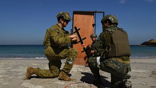 Australian Army Sapper Nicholas Field (left) with the 2nd Combat Engineer Regiment instructs how to set a charge on a makeshift door to marines with the Philippine's 8th Marine Battalion during training at the Philippine Marine Corp Barracks Gregorio Lim in Ternate, Luzon, Philippines. 