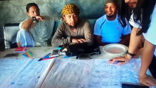 The purported leader of Islamic State's south-east Asia branch, Isnilon Hapilon, centre, at a meeting of militants at an undisclosed location. 
