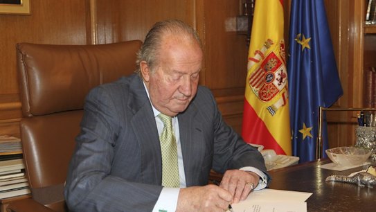 In this photo released by Spain's Royal Palace, King Juan Carlos signs a letter opening the way for his abdication.