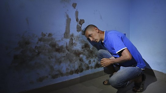 Olekdsndr Fayizov, 41yrs a civilian computer technician demonstrates where Russian soldiers beat his head against the blood stained wall of a room used as a cell in the basement of the Trostyanets railway station used by the Russians as a base, where he was interrogated and tortured. 
