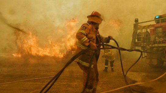 Spot fires threaten to overwhelm RFS volunteer firefighters at the Hillville fire on NSW Mid north coast. Constant swirling winds and dry fuel has allowed the fire to spot often threatening and destroying homes.