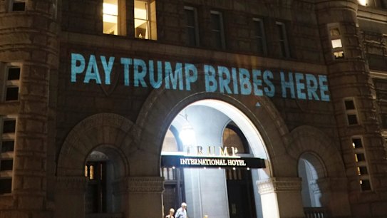 US President Donald Trump's Washington hotel is illuminated with projected messages by Robin Bell, an artist and filmmaker. 