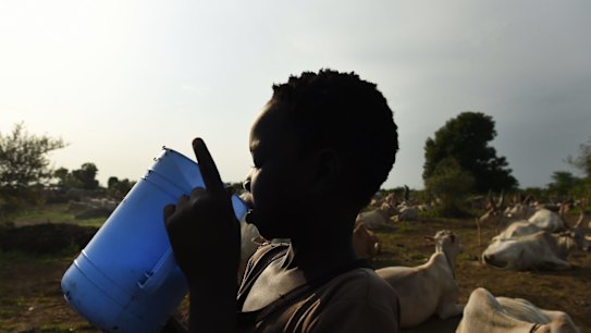 A boy drinks fresh milk at the cattle camps that have popped up on the outskirts of Bentiu in South Sudan.