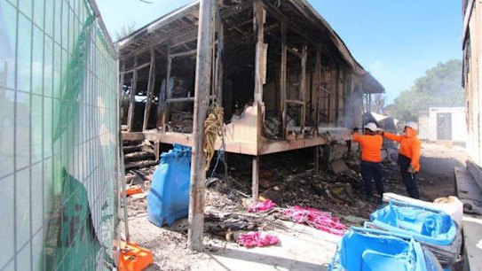 Workers extinguish last smouldering embers after the disturbance.    Damage after Nauru disturbance  21-07-2013 -  Workers extinguish last smouldering embers after the disturbance.