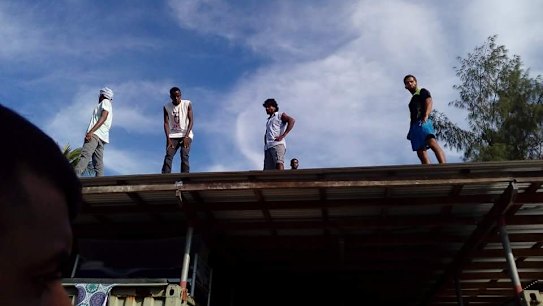Refugees scaled the roof of a compound inside the decommissioned detention centre as police entered.