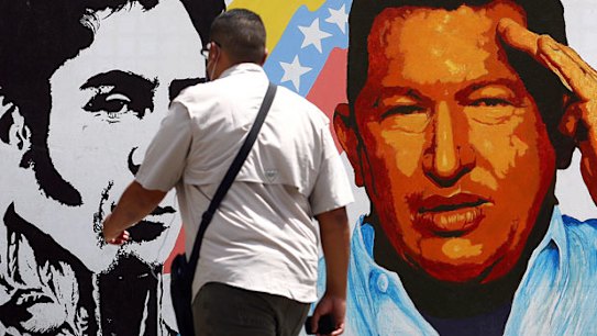 A man walks past a mural portraying the Venezuelan flag, President Hugo Chavez and South American liberator Simon Bolivar at in Caracas.
