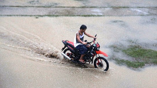 A resident rides his motorcycle across a flooded area as rains from Typhoon Mangkhut begin to affect Tuguegarao city, Cagayan province, northeastern Philippines on Friday, Sept. 14, 2018. Typhoon Mangkhut retained its ferocious strength and slightly shifted toward more densely populated coastal provinces on Friday as it barreled closer to the northeastern Philippines, where a massive evacuation was underway. (AP Photo/Aaron Favila)