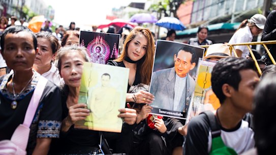 People line the streets outside Siriraj Hospital ahead of the procession that took King Bhumibol's body to the Grand Palace in Bangkok on Friday.