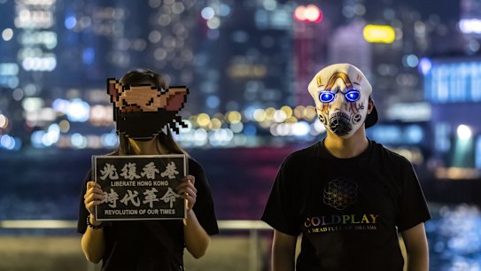 Demonstrators wear face masks while forming a human chain during the Face Mask Way event in the Tsim Sha Tsui district of Hong Kong, China, on Friday, Oct. 18, 2019.
