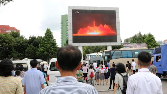 People watch a news broadcast on a missile launch in Pyongyang.