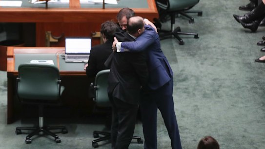 Minister for Environment and Energy Josh Frydenberg embraces Labor MP Ed Husic after he spoke in the House of Representatives in response to Senator Fraser Anning's first speech in the Senate, at Parliament House in Canberra on  Wednesday 15 August 2018. fedpol Photo: Alex Ellinghausen