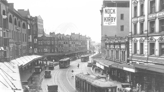 View of George Street from Grosvenor Street, looking northward to the Sydney Harbour Bridge that is under construction, 1931
SMH Picture by Staff

Cityscape, city. Skyline, pedestrians, shops, cars, automobiles, transport, tram, trams, tramway, tramline, public transport, 1930s, black and white, history, archival