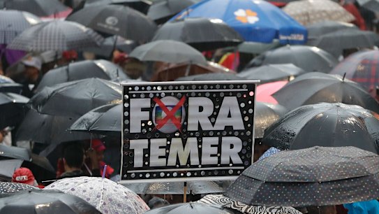 Demonstrators march against Brazil's President Michel Temer, holding banners reading "Temer Out", in Sao Paulo, on Sunday.