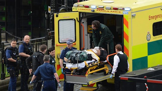 An attacker is treated by emergency services outside the Houses of Parliament in London.