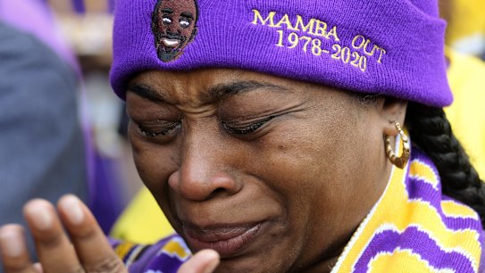 Lioness Saxa cries as she watches the live stream of a public memorial for Kobe Bryant and his daughter, Gianna, outside the Staples Center in Los Angeles, Monday, Feb. 24, 2020.