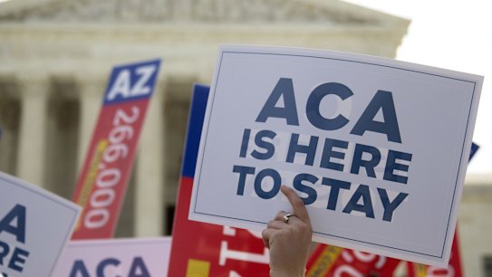 A demonstrator in support of US President Barack Obama's healthcare law, the Affordable Care Act after the US Supreme Court ruled 6-3 to save Obamacare tax subsidies in 2015. 