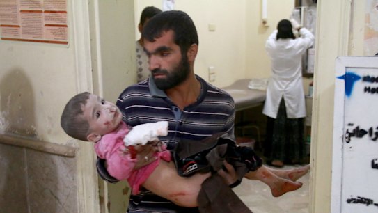 A Syrian man carries his son to a field hospital after Syrian and Russian army carried out airstrikes in Aleppo.