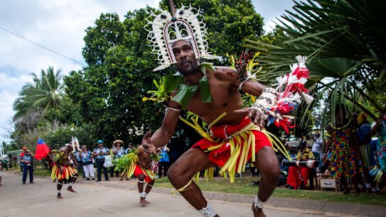 Dancers in a memorial parade through Mer Village.
