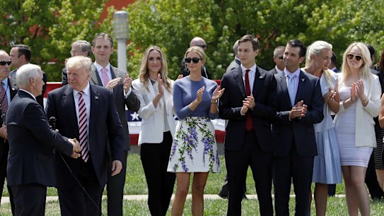 Donald Trump shakes now Vice-President Mike Pence's hands as his sons Eric, daughter-in-law Lara Yunaska, daughter Ivanka, Ivanka's husband Jarred Kushner, son Donald jnr and wife Vanessa, and daughter Tiffany look on during the campaign.