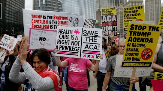 Protesters in Chicago celebrate Donald Trump's defeat on healthcare law repeal.